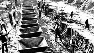 Das schwarzweiß Bild zeigt, dass Straßenbau 1935 Handarbeit war.
